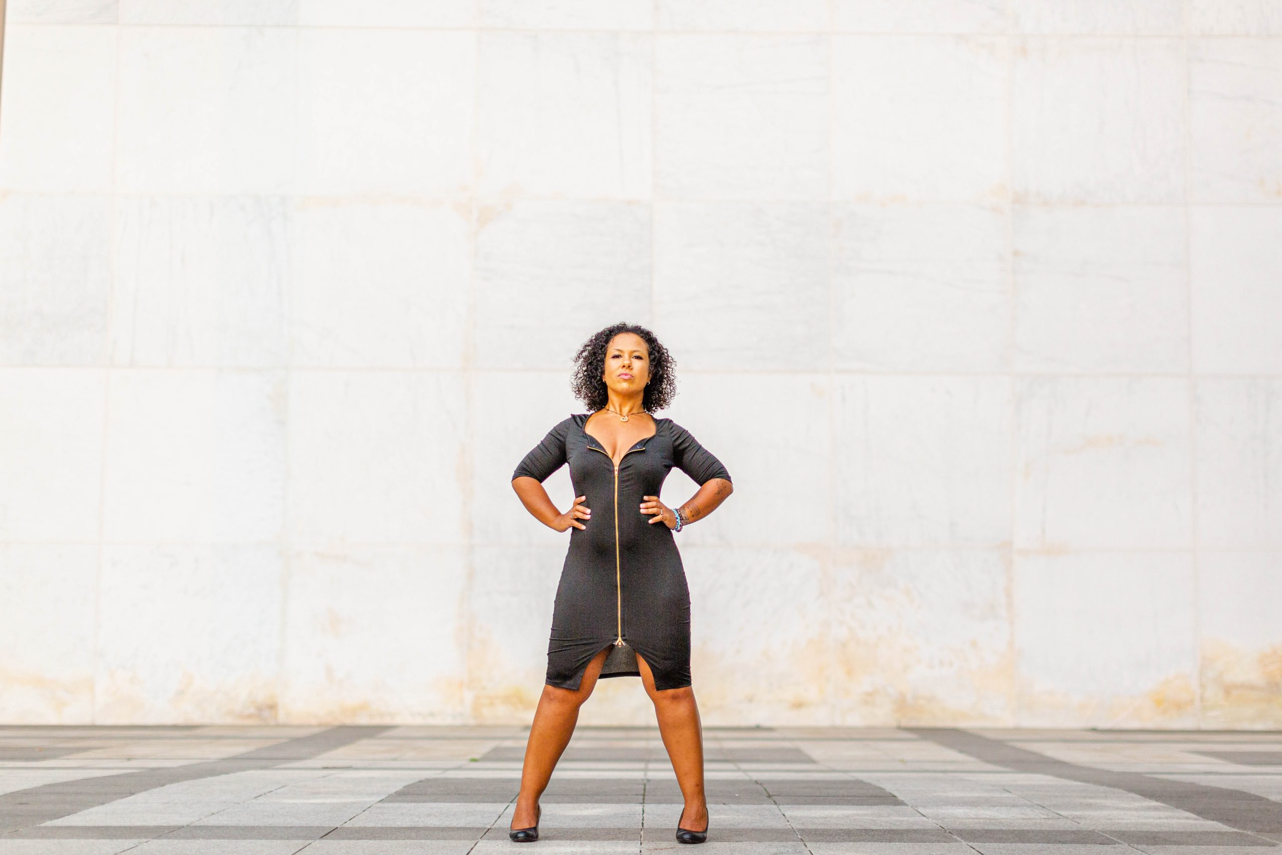a woman stands against a wall